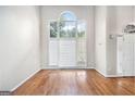 Inviting living room featuring hardwood floors, neutral paint, and a statement arched window at 4875 Ben Hill Rd, College Park, GA 30349