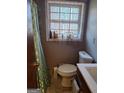 Cozy bathroom featuring a window with natural light, toilet, and sink at 1667 Park Pl, Lithia Springs, GA 30122