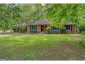 Traditional brick home featuring a well-manicured lawn and mature shade trees at 205 Olde Oak Dr, Jonesboro, GA 30238