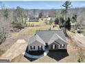 An aerial view showcases the house and its surroundings and a lush lawn to enjoy outdoor activities at 321 Harris Ave, Locust Grove, GA 30248