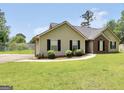 Inviting single-story home featuring a lush lawn, neatly trimmed shrubs, and a paved walkway to the entrance at 321 Harris Ave, Locust Grove, GA 30248