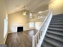 Inviting living room featuring high ceilings, a fireplace, laminate flooring and a staircase to the second level at 3228 Rivermist Cv, Decatur, GA 30034