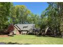 Charming single-Gathering home with brick accents, lush landscaping, and a well-manicured lawn surrounded by mature trees at 107 Rolling Grn, Peachtree City, GA 30269