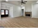 Bright living room with wood flooring features a brick fireplace and double front doors at 4601 Parkwood Rd, Social Circle, GA 30025