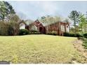 Charming brick home with a lush green lawn and mature trees at 1090 Crown River Pkwy, Mcdonough, GA 30252