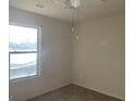 A bright bedroom with a window, ceiling fan, and carpeted floors at 10950 Wheeler Trce, Hampton, GA 30228