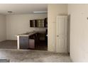 Open-concept kitchen area with dark wood cabinets and a breakfast bar at 10950 Wheeler Trce, Hampton, GA 30228