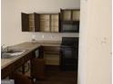 Kitchen featuring wood cabinets, a black stove, and granite countertops at 10950 Wheeler Trce, Hampton, GA 30228