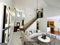 Spacious living room featuring tall ceilings and a staircase with iron spindles at 2481 Weatherstone Cir, Conyers, GA 30094