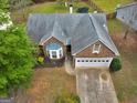 Aerial view of a brick home with a well-manicured lawn and a two-car garage at 105 Lantana Dr, Locust Grove, GA 30248
