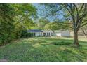 Well-maintained single-story home with a lush front yard and mature trees offering shade at 2340 Rolling Acres Sw Dr, Conyers, GA 30094