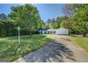 This home features a large front yard and a long driveway at 2340 Rolling Acres Sw Dr, Conyers, GA 30094
