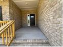 Covered front porch with brick wall and wood railing at entrance to home at 3383 Milan Ct # 4 Plapprox Sqft 1, Douglasville, GA 30135