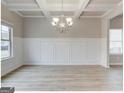 Formal dining room featuring a coffered ceiling, elegant chandelier, and wainscoting at 300 San Anselmo St, Locust Grove, GA 30248