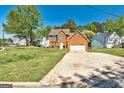 Two-story brick home featuring a well-manicured lawn and a two-car garage in a neighborhood setting at 3612 River Mill Ct, Ellenwood, GA 30294