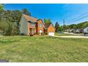 Brick and siding home with an attached garage, showcasing well-kept lawn and shrubbery at 3612 River Mill Ct, Ellenwood, GA 30294