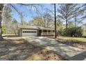 View of house from driveway showcasing attached garage, and brick porch at 736 Stagecoach Rd, Stockbridge, GA 30281