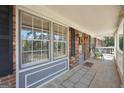 Covered front porch with stone floor, white railing, and decorative floral wreath at 736 Stagecoach Rd, Stockbridge, GA 30281
