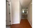 Bright hallway showcasing hardwood flooring and an open view into a spacious living area with fireplace at 10119 Commons Way, Jonesboro, GA 30238