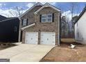 Two-story brick home with a two-car garage and a well-manicured lawn in residential area at 5318 Tolar Rd # 25, South Fulton, GA 30213