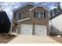 Two-story brick home with a two-car garage and a well-manicured lawn under a blue sky at 5318 Tolar Rd # 25, South Fulton, GA 30213