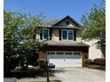 Charming two-story home features a red brick facade with a two-car garage and a well-manicured lawn at 2517 Oakleaf Rdg, Lithonia, GA 30058