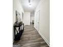 Inviting hallway with wood-look floors, neutral walls, and a stylish console table with decorative accents at 2517 Oakleaf Rdg, Lithonia, GA 30058