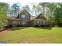 Charming two-story home featuring a well-maintained lawn and lush landscaping at 4360 Derrick Rd, South Fulton, GA 30349