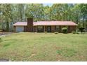 Traditional ranch with brick exterior, red metal roof, and attached garage at 361 Cecil Hunter Rd, Moreland, GA 30259