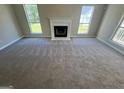 Bright living room with neutral carpet, fireplace, and large windows, creating a cozy atmosphere at 194 Bay Court Dr, Stockbridge, GA 30281
