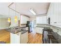 Open kitchen with white cabinets, dark granite countertops and stainless steel appliances at 1201 Turtle Creek Ct, Lawrenceville, GA 30043