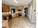 Bright kitchen with stainless appliances, wood cabinetry, and tile flooring at 4254 Wood Cove Dr, Snellville, GA 30039