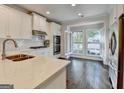 Modern kitchen with white cabinets, stainless steel appliances, and hardwood floors at 7920 Willoughby Ct, Alpharetta, GA 30005