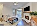 Cozy living room with a fireplace, hardwood floors, and access to the outdoor patio at 7920 Willoughby Ct, Alpharetta, GA 30005