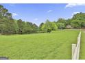 Picturesque view of the expansive green field surrounded by trees, showcasing the property's natural beauty at 115 Ebenezer Church Rd, Fayetteville, GA 30215