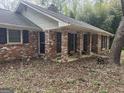 Side view of the charming brick home showing the covered front porch and brick support columns at 130 Sandy Dr, Stockbridge, GA 30281