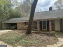 View of the charming brick home with an attached garage featuring a classic car inside at 130 Sandy Dr, Stockbridge, GA 30281