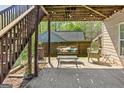 Relaxing covered back patio area with cushioned swing and seating, perfect for enjoying the outdoors at 2515 Harbins Mill Dr, Dacula, GA 30019
