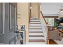 Welcoming entryway with hardwood stairs, a view into the living room, and decorative wall art at 2515 Harbins Mill Dr, Dacula, GA 30019