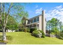 Charming two-story home with manicured lawn, landscaping and a large tree providing shade at 2515 Harbins Mill Dr, Dacula, GA 30019