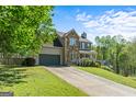 Charming two-story home with a stone facade and well-manicured lawn with a large driveway at 2515 Harbins Mill Dr, Dacula, GA 30019