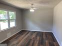 Spacious room with beautiful wood floors, neutral paint, ceiling fan, and a bright window at 300 Wood Rd., Hampton, GA 30228
