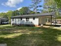 This single story home features a covered parking area, white siding and a neatly maintained lawn at 300 Wood Rd., Hampton, GA 30228