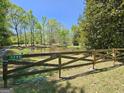 Scenic view of a pond bordered by a wooden fence and lush green trees and grass at 1200 Ridgeway Rd, Covington, GA 30014