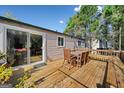 A spacious wooden deck with outdoor dining furniture and sliding door entrance at 2406 Redfield Dr, Norcross, GA 30071