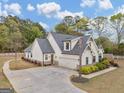 White two-story home featuring an attached two-car garage, long driveway, and landscaped yard at 319 S Mount Carmel Rd, Mcdonough, GA 30253