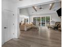 Open-concept living room with beamed ceilings, gray flooring, and a large sliding glass door at 319 S Mount Carmel Rd, Mcdonough, GA 30253