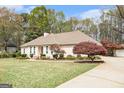 Single-story home boasts a well-manicured lawn and mature landscaping at 110 Kylemore Pass, Tyrone, GA 30290