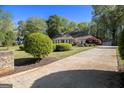 Traditional home with a long driveway, landscaped front yard, and lush green surroundings at 110 Kylemore Pass, Tyrone, GA 30290