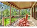 Cozy covered porch featuring rocking chairs and a serene view of the surrounding greenery at 140 Crimson Rdg, Tyrone, GA 30290